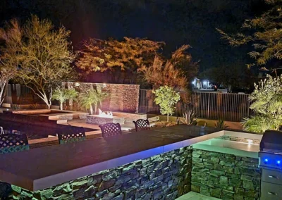“Modern Scottsdale backyard featuring low-voltage LED lighting around the bar, seating, and firepit area, installed by Eclipse Landscape & Design.”