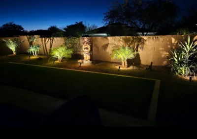 Back yard lighting with trees and statue