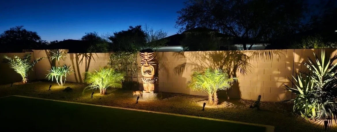 Back yard lighting with trees and statue