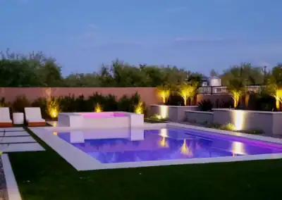 “Nighttime backyard scene with LED pool lighting and illuminated landscape features.”